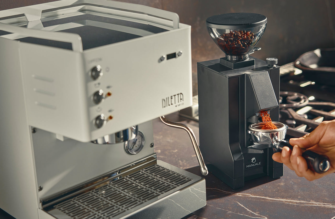 Diletta Mio espresso machine paired with a Eureka Mignon grinder dosing fresh grounds into a portafilter