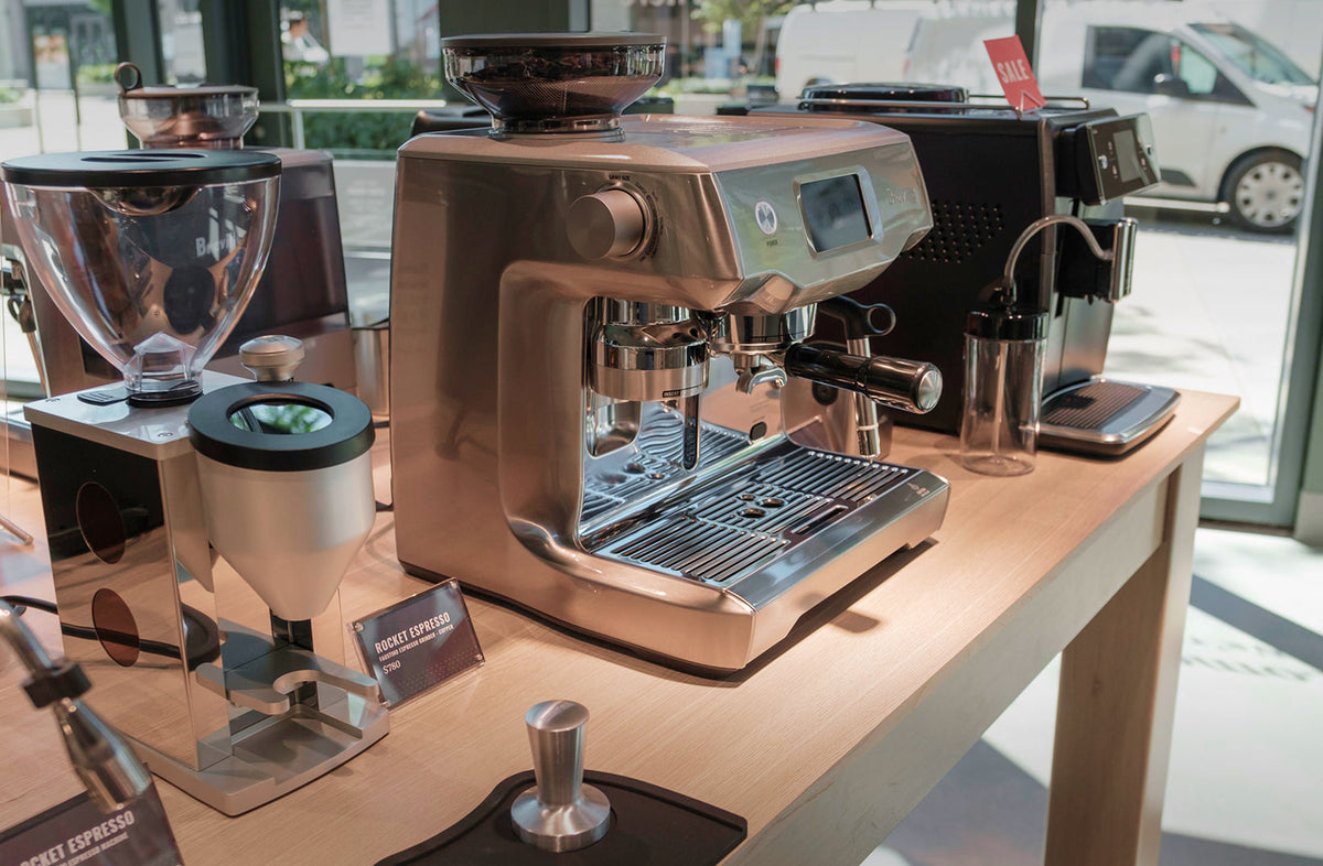 Espresso machines and grinders on display at a Seattle Coffee Gear showroom counter