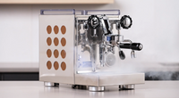 Rocket Espresso Appartamento espresso machine in stainless steel with copper side panel cutouts on a kitchen countertop